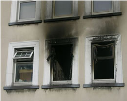 Three burnt windows from a fire damaged flat.