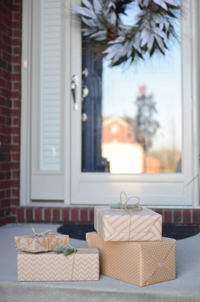 Beige and white gift wrapped presents placed on a porch step.