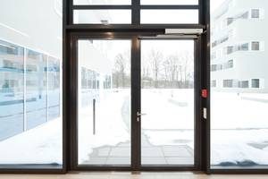 Double, glass pane automatic doors with snow outside.